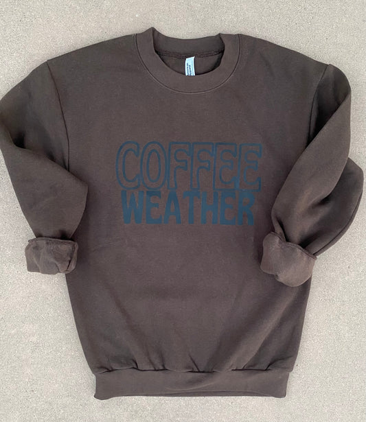 dark brown sweatshirt with "COFFEE WEATHER" in black stacked on the front of the sweatshirt