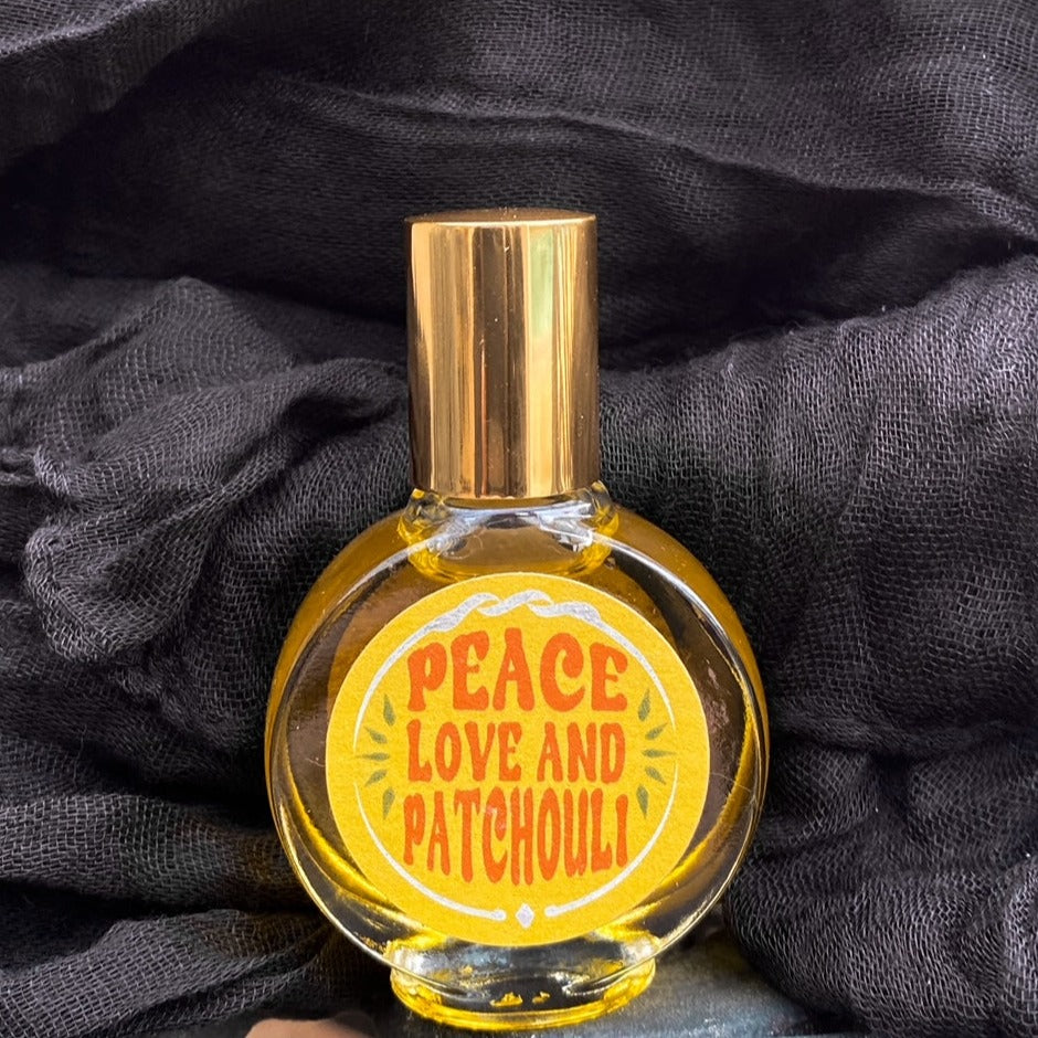 Glass bottle of patchouli oil with a gold twist off top. A yellow round label with Peace Love and Patchouli written on the front.