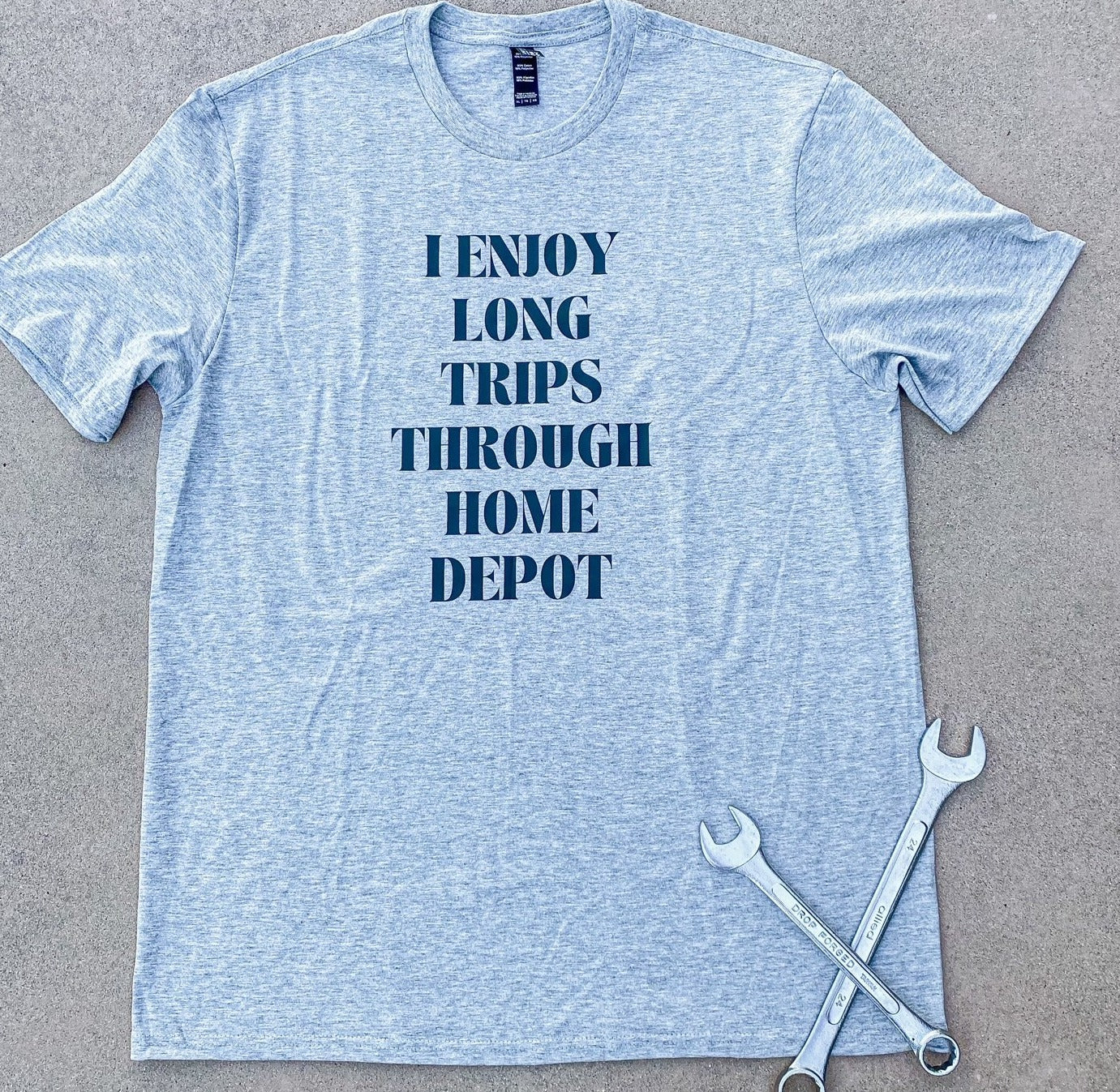 Grey t-shirt with "I ENJOY LONG TRIPS THROUGH HOME DEPOT" printed on the front in black