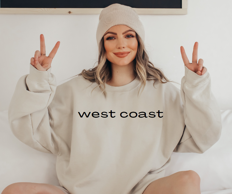 Sand colored sweatshirt with west coast printed in black across the chest